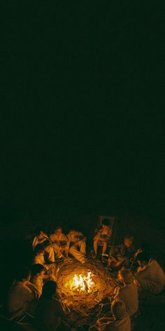 people sitting around a campfire in the dark