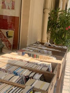 a bunch of books that are sitting in a box on the sidewalk outside some buildings