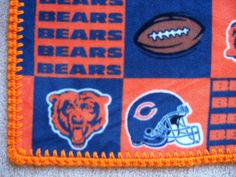 an orange and blue chicago bears blanket with footballs, bears and bears on it