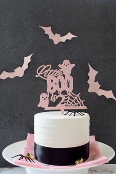 a white cake with pink frosting and bats on it