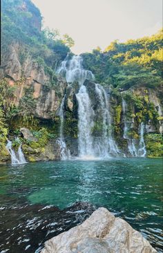 a large waterfall in the middle of a body of water