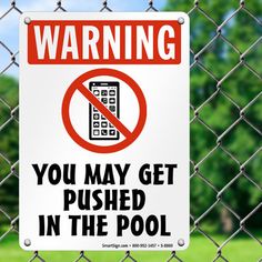 a sign on a chain link fence warning you may get pushed in the pool with a cell phone