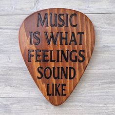 a wooden guitar pick with the words music is what feelings sound like