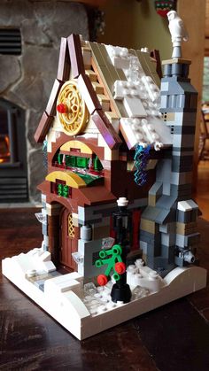 a lego house is shown on a table in front of a fire place and fireplace