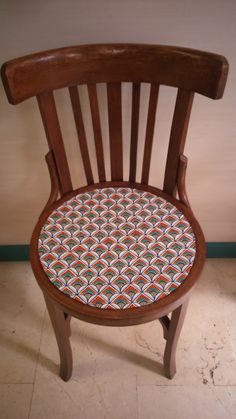 a wooden chair with a patterned seat cushion