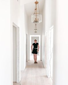 a woman is standing in an empty hallway