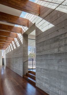 the inside of a house with wood floors and skylights on the ceiling is made of concrete