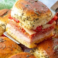 several sandwiches stacked on top of each other in a glass dish with a knife and fork