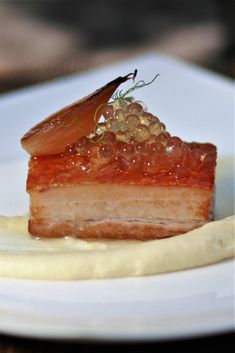 a piece of cake sitting on top of a white plate covered in jelly and garnish