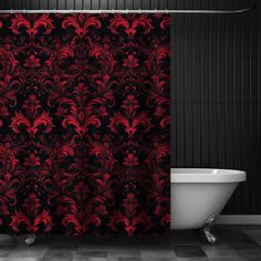 a bath tub sitting next to a shower curtain covered in red and black swirls