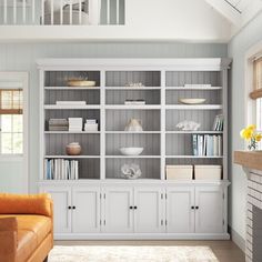 a living room filled with furniture and a white bookcase next to a fire place