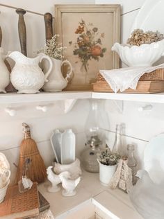 two shelves with dishes and vases on them