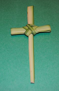 a cross made out of wood sitting on top of a green table