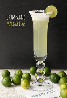 a margarita with limes around it on a table