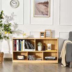 a living room filled with furniture and a clock above the bookshelf on the wall