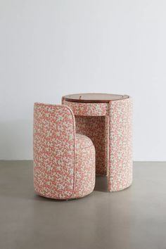 two round tables sitting on top of a cement floor next to each other, one with a flowered design