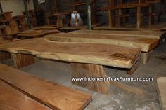 several wooden benches are lined up in a warehouse