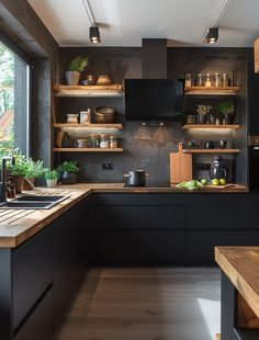 a kitchen with black cabinets and wooden counter tops next to an open window that looks out onto the backyard