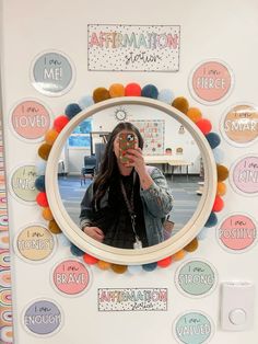 a woman taking a selfie in front of a mirror with stickers on it