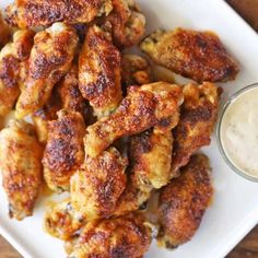 a white plate topped with chicken wings and ranch dressing