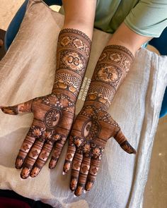 two hands with henna tattoos on them