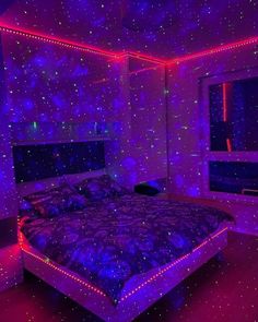 a bed in a room with purple and blue lights on the walls, along with stars