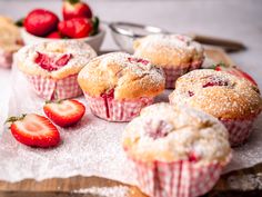 strawberry muffins with powdered sugar and fresh strawberries on the counter top