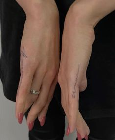 two hands with tattoos on them holding onto each other's fingers and their thumbnails