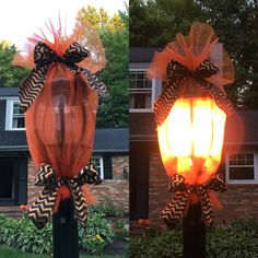 two orange and black lanterns with bows on them in front of a brick house at night