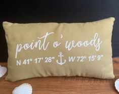 a pillow with the words point o'wood on it next to seashells