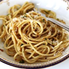 a white plate topped with pasta covered in sauce and parmesan sprinkles