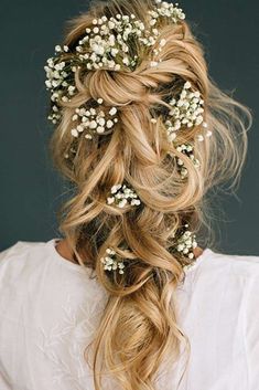 a woman with long blonde hair and flowers in her hair is wearing a white shirt