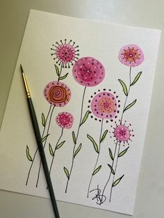 a drawing of pink flowers on white paper with a black pencil next to it and a watercolor pen