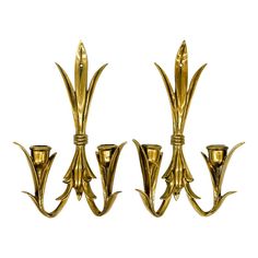 three golden metal sconces on a white background