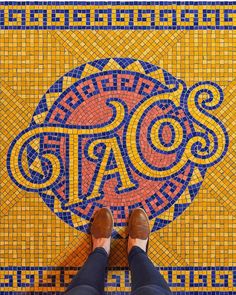 a person standing on top of a colorful tile floor