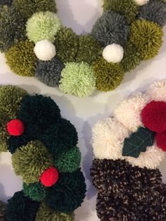 three knitted christmas wreaths with pom - poms and holly on them