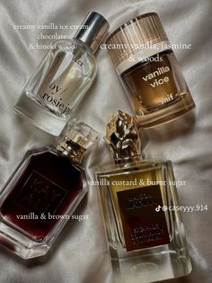 three bottles of perfume sitting on top of a bed