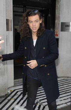 a man with long hair and sunglasses walking down the street