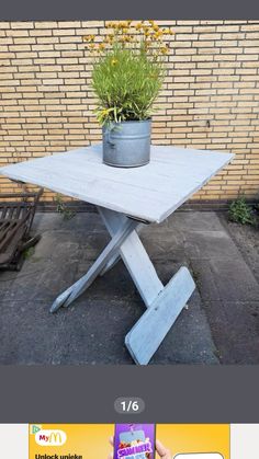 a table with a potted plant sitting on it's top and an advertise