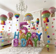 the balloons are all over the room and it says happy birthday