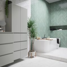 a bathroom with green herringbone tiles and white furniture, including a plant in the bathtub