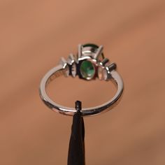 It is lab emerald ring. The main stone is 7mm*9 mm oval cut.weight about 1.58 carats. The basic metal is sterling silver and plated with rhodium. To change the metal to a solid gold (white/rose) or platinum is also available, please ask for a quotation if you want. You can also go to my shop Home for more elegant rings: https://www.etsy.com/shop/godjewelry?ref=hdr_shop_menu Emerald is May birthstone More emerald rings: https://www.etsy.com/shop/godjewelry?section_id=20709240 Customization is alw Emerald Oval Cabochon Ring For Anniversary & May Birthstone, Oval Emerald Sterling Silver Promise Ring, Oval Sterling Silver Emerald Promise Ring, Oval Emerald Promise Ring In Sterling Silver, Oval Emerald Birthstone Ring In White Gold, Oval Emerald Ring With Polished Finish For Anniversary, Oval Emerald Ring For Anniversary With Polished Finish, Emerald Promise Ring With Polished Finish For May Birthstone, Fine Jewelry Emerald Oval Cabochon Promise Ring