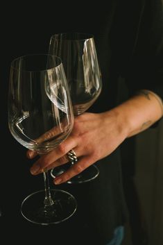 a person holding two wine glasses in their hands