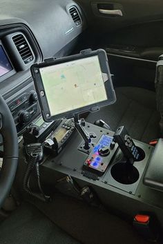 the inside of a car with a gps device and steering wheel control system in it