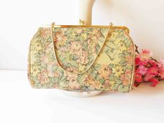 "This 1950s tapestry handbag has soft beautiful color. The background is cream with pink flowers and green leaves. It has a goldtone frame and a kiss lock. This is a vintage Harold Levine purse HL USA. The bag interior is pale gold with one pocket. This beautiful bag is large enough to hold an iPhone. This tapestry clutch also includes a chain strap. A lovely handbag for your special occasion. MATERIAL: Tapestry CONDITION: Good SIZE: 9\" x 6\" COLOR: Cream, pink, green" Gold Tapestry Rectangular Bag, Gold Rectangular Bag For Luncheon, Tapestry Handbag, Tapestry Handbags, Wedding Bags, Bag Interior, Handbag Vintage, Wedding Bag, Pale Gold