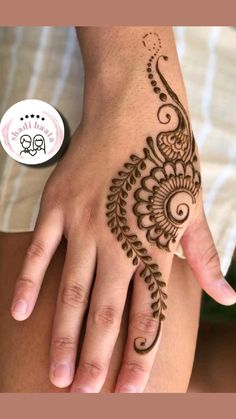 a woman's hand with a henna tattoo on her left arm and fingers