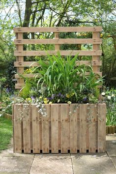 a wooden planter filled with lots of plants