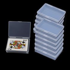 a stack of plastic playing cards in front of a black background with the lid open