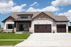 a large house with two garages in the front yard