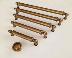 an assortment of brass hardware on a white surface